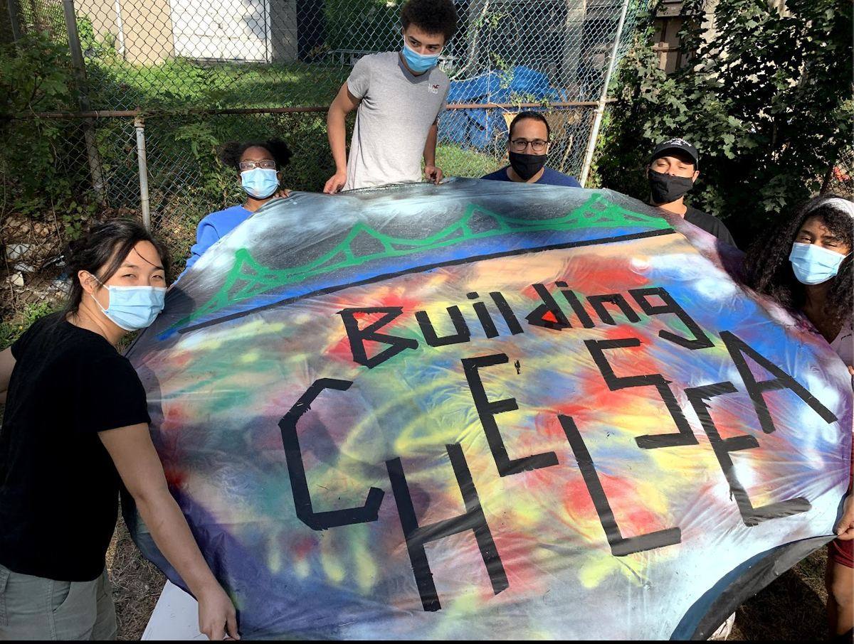 Youth with a Building Chelsea banner